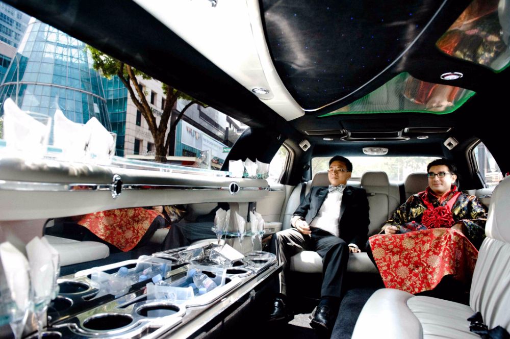 Groom and best man inside limousine